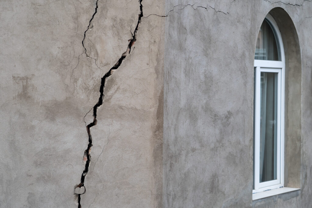 Fachada con grietas y desconchones antes de reparar en Castellón