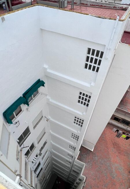 Patio de luz deteriorado antes de reparación y pintura en comunidad de Castellón